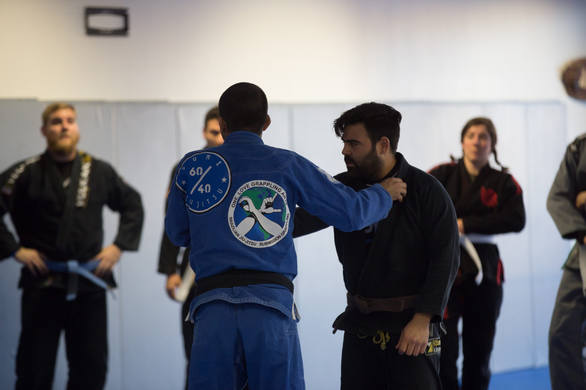 A man in blue and black uniform getting ready to do a judo move.