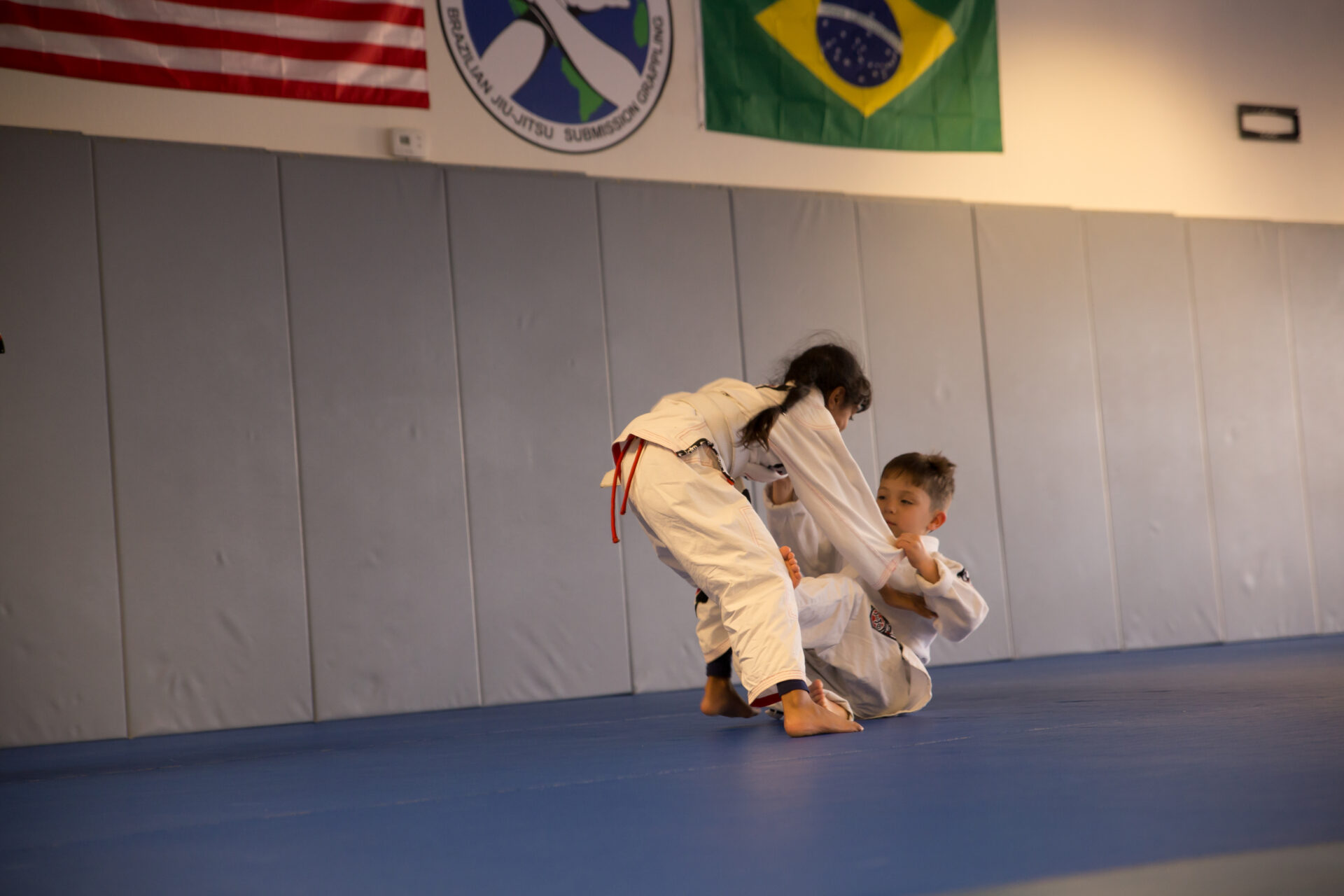 Two people practicing martial arts in a gym.